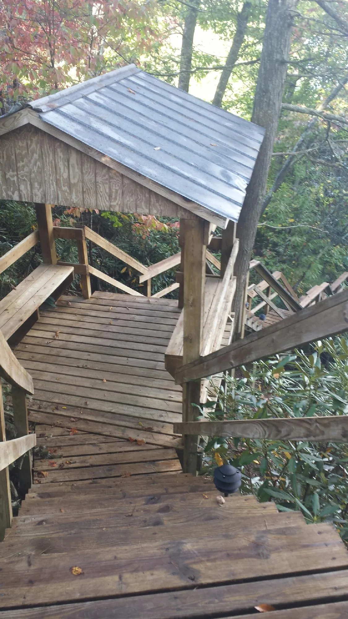 Metal roofed shelter over wooden steps on a wooded walkway — Skylight Repair & Installation work by our crew in Prescott